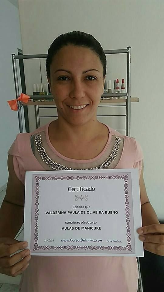 Foto de uma aluna com certificado em mãos.